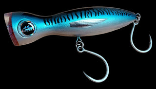 A metallic blue and silver fishing lure with black tiger stripes, a realistic eye, and two treble hooks attached, shown against a plain white background.