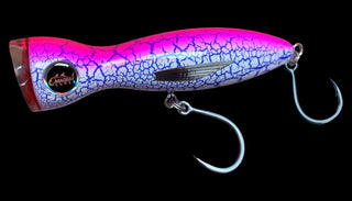 A hard plastic fishing crankbait lure with a vibrant pink and purple body featuring a blue crackle pattern, a red tail, and two silver metal hooks.